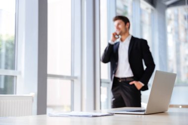 Laptop ve arka plan üzerinde işadamı ile office belgelerinde