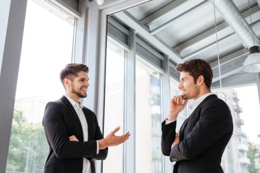 Gülümseyen ve ofisinde konuşmak iki iş adamları