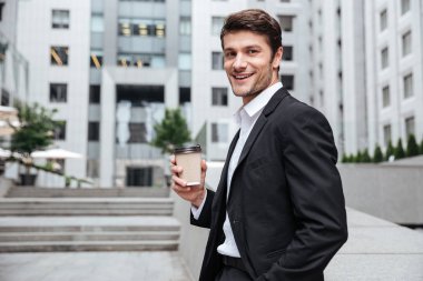 Genç işadamı içme kahve iş merkezi yakınlarındaki gülümseyen