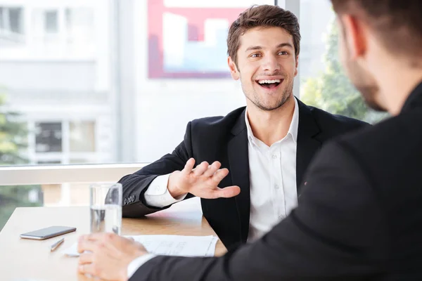 Vrolijke jonge zakenman te praten met zijn collega — Stockfoto