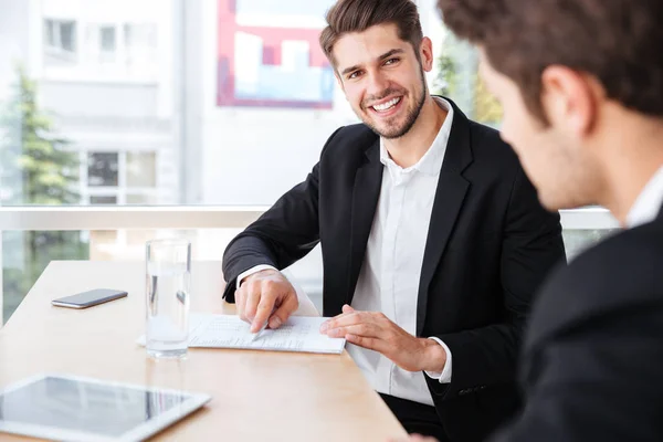 Two businessmen talking and working with documents in office — Stock Photo, Image