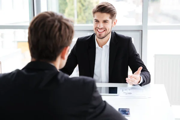 Dos hombres de negocios alegres usando tableta y trabajando en reuniones de negocios —  Fotos de Stock