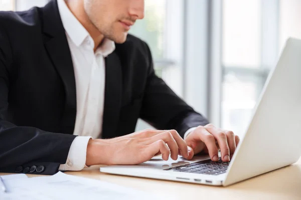 Biznesmen siedzi i korzysta z laptopa w biurze — Zdjęcie stockowe