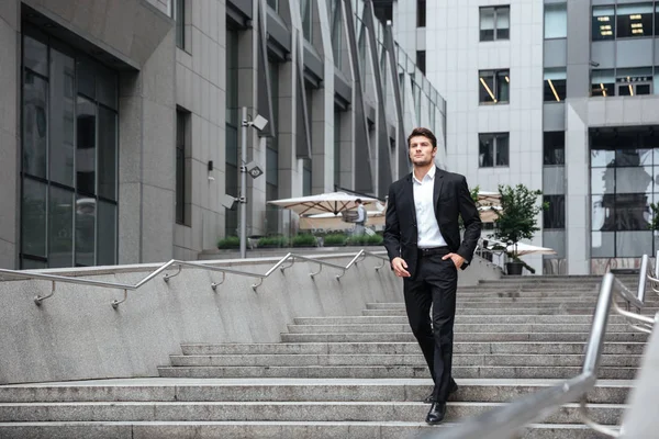 Hombre de negocios serio caminando cerca del centro de negocios — Foto de Stock
