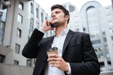 Cep telefonuyla konuşurken almak uzakta kahve ile işadamı