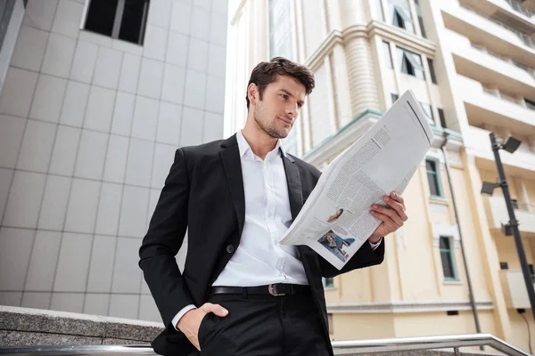 Geschäftsmann liest Zeitung in der Stadt — Stockfoto