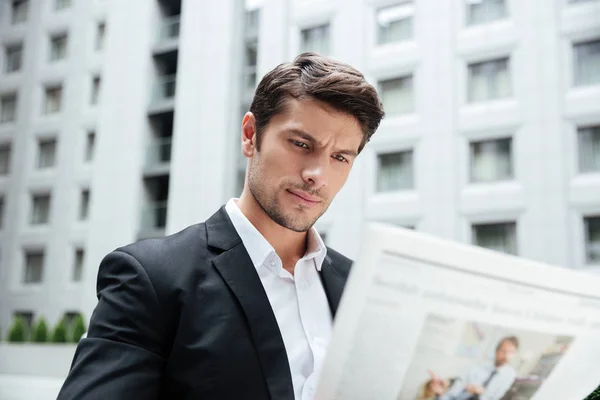 Empresario leyendo periódico en la ciudad — Foto de Stock