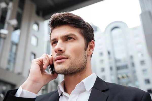 Businessman talking on mobile phone in the city — Stock Photo, Image