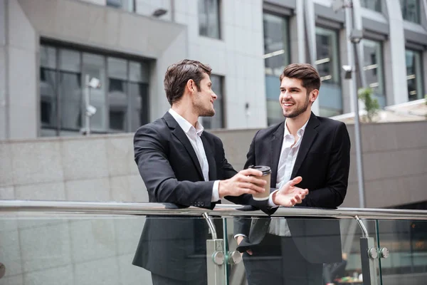 Two businessmen talking and drinking coffee in the city — Stock Photo, Image