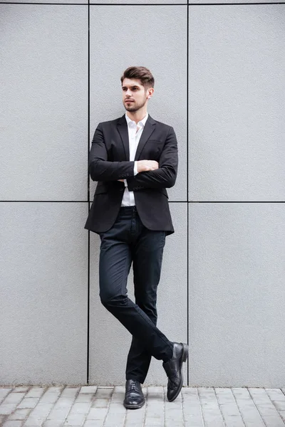 Jovem empresário confiante de pé de braços cruzados — Fotografia de Stock