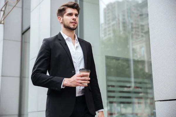 Zakenman wandelen en koffie drinken buitenshuis — Stockfoto