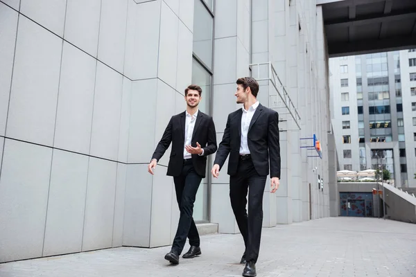 Deux hommes d'affaires marchant et parlant dans la ville — Photo