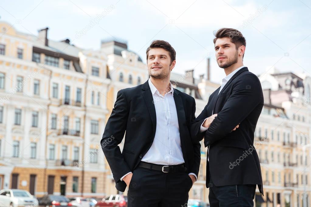 Two confident businessmen standing outdoors