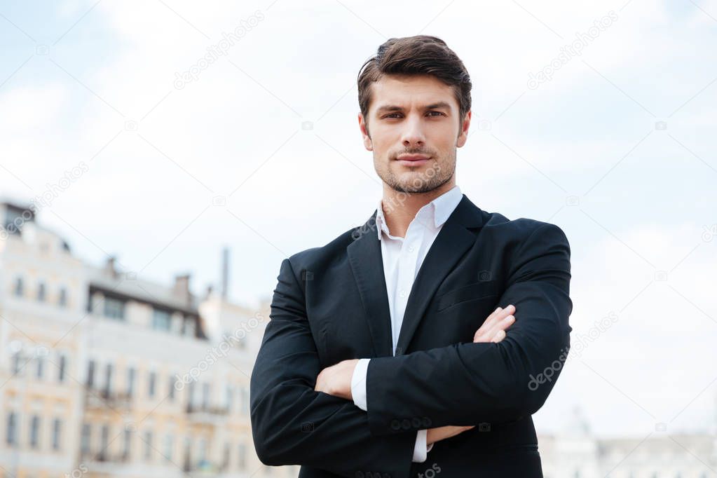 Businessman standing with arms crossed outdoors
