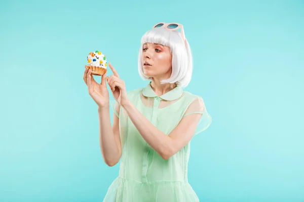 Pretty blonde young woman holding cupcake — Stock Photo, Image