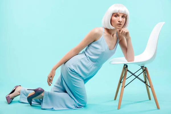 Schöne blonde junge Frau posiert mit Stuhl — Stockfoto