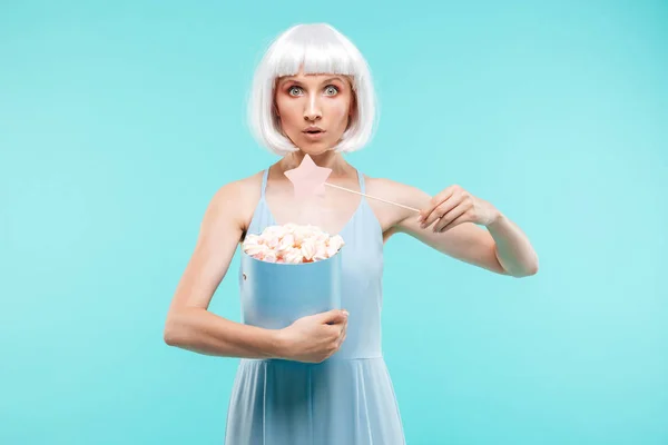 Mooie jonge vrouw met marshmallows permanent en met behulp van de toverstaf — Stockfoto