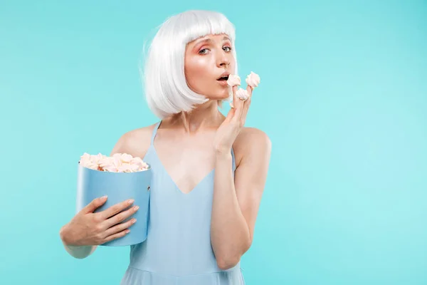 Mooie blonde jonge vrouw marshmallows eten uit het vak — Stockfoto