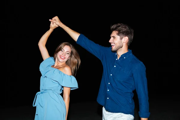 Glada unga par dansar på stranden på natten — Stockfoto