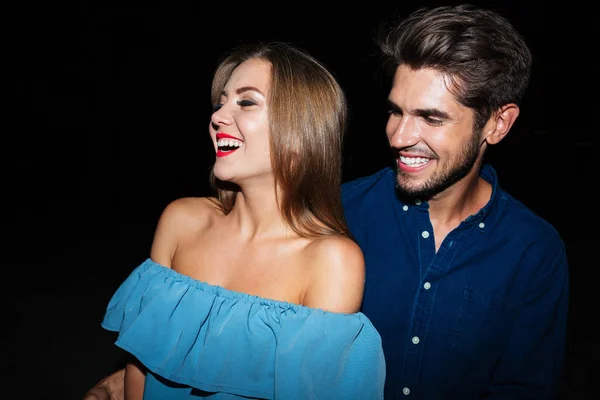 Fröhliches junges Paar, das nachts zusammen lacht — Stockfoto