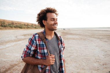 Mutlu kıvırcık Afrika genç adam sırt çantası ile