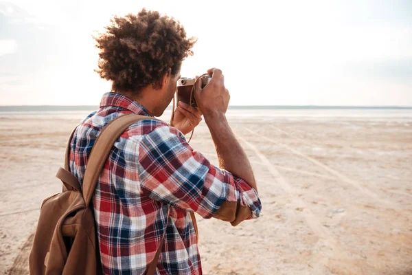 Vissza view afrikai férfi fotózni a strandon — Stock Fotó