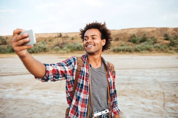 Felice uomo africano prendendo selfie con il telefono cellulare all'aperto — Foto Stock