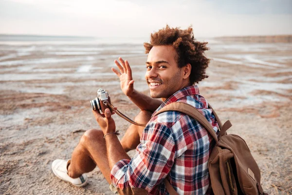 Glada afrikanska man tar bilder med vintage kamera på stranden — Stockfoto