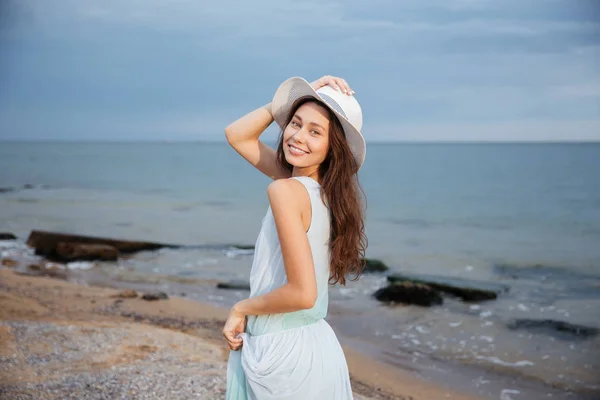 Boldog nő kalapban séta a tengerparton — Stock Fotó