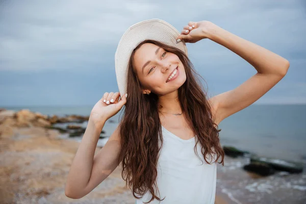 Усміхнена мила молода жінка в капелюсі на пляжі — стокове фото