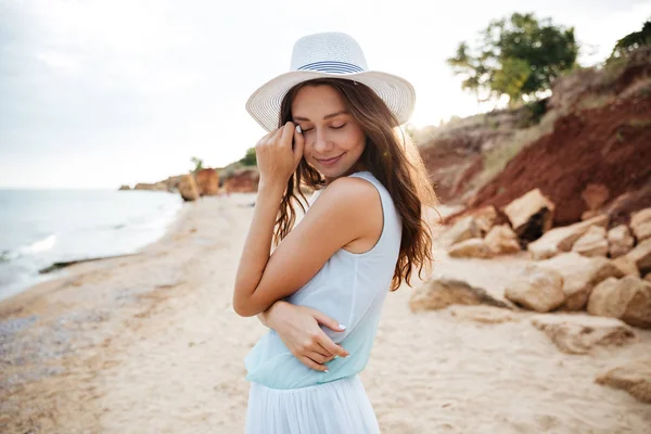 Sinnliche Frau mit weißem Hut am Strand — Stockfoto