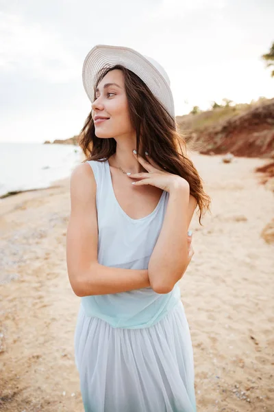 Glückliche hübsche junge Frau, die am Strand spazieren geht und träumt — Stockfoto