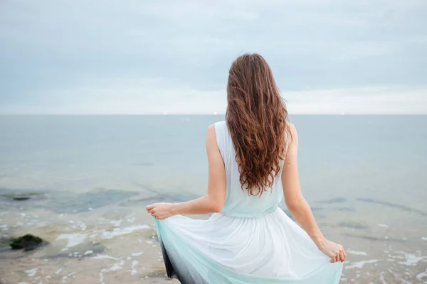 Vista posteriore di bella giovane donna in piedi sulla spiaggia — Foto Stock