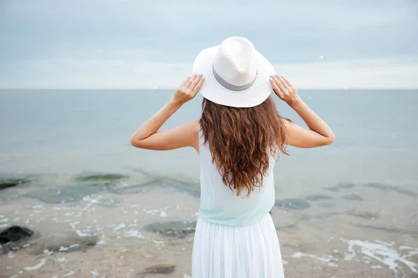 Vista trasera de la mujer de pie y mirando al mar —  Fotos de Stock