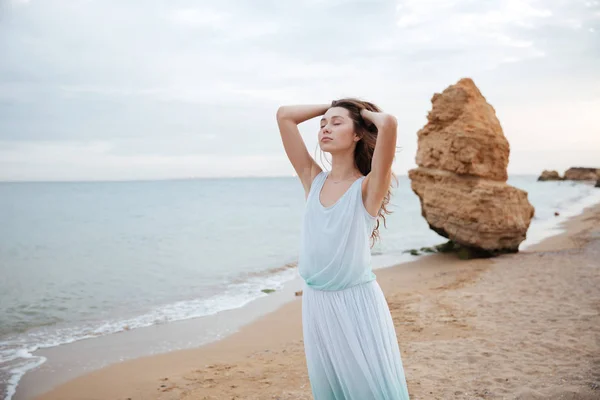 Sensual mujer de pie con los ojos cerrados en la playa — Foto de Stock