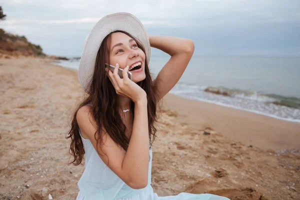 Mujer feliz hablando por teléfono móvil y riendo en la playa — Foto de Stock