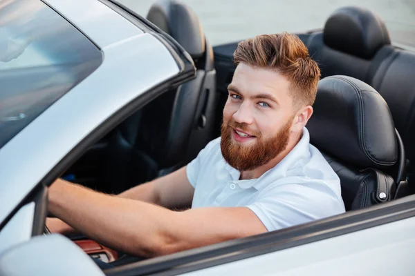 Lycklig man kör cabriolet och tittar på kameran — Stockfoto