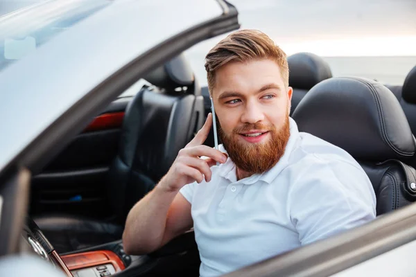 Jovem falando em seu telefone e dirigindo um carro — Fotografia de Stock