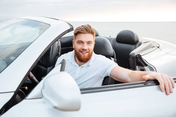 Porträt eines hübschen jungen Mannes, der in sein Auto steigt — Stockfoto