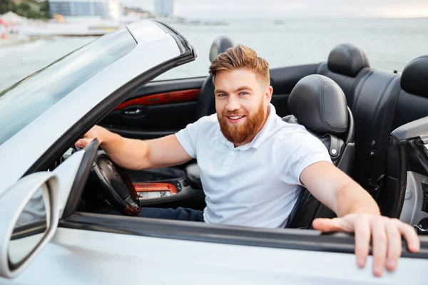 Un homme barbu souriant descend de sa voiture — Photo