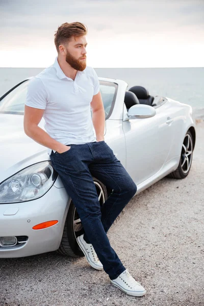 Retrato de un hombre confiado apoyado en su coche de lujo —  Fotos de Stock