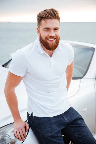 Bello uomo barbuto in piedi vicino alla macchina moderna — Foto Stock
