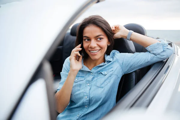 Sorrindo mulher dirigindo carro e falando no telefone celular — Fotografia de Stock