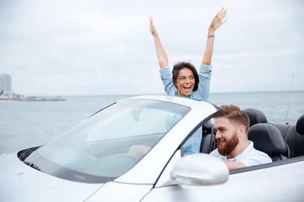 Feliz joven pareja disfrutando de viaje por carretera en su convertible —  Fotos de Stock