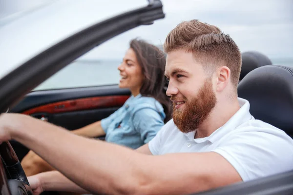 Lyckliga paret leende när du sitter inne i sin Cabriolet — Stockfoto