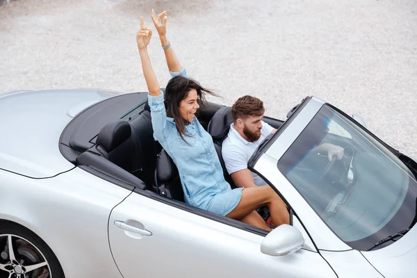 Heureux jeune couple profitant d'un road trip dans leur cabriolet blanc — Photo