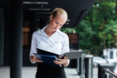 Gülümseyen işkadını klasörlerle ayakta