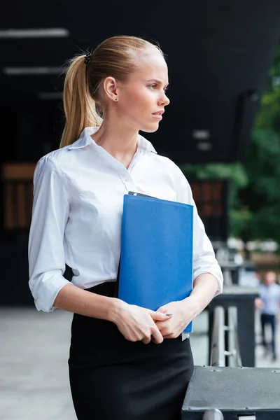 物思いにふける若いビジネス女性 blue フォルダーを押しながらよそ見 — ストック写真