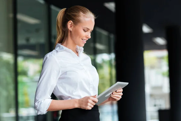 Affärskvinna med digital tablett stående vid glasräcke — Stockfoto