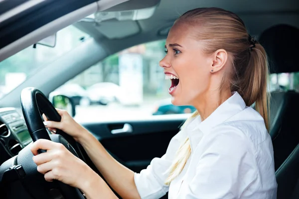 Mujer de negocios asustada conduciendo su coche — Foto de Stock